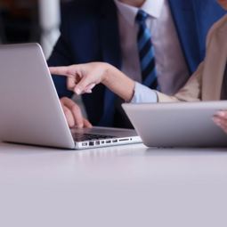 person holdering tablet pointing at laptop News Article