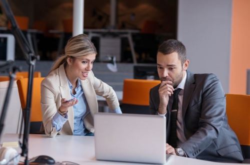 Woman and man talking looking at laptop